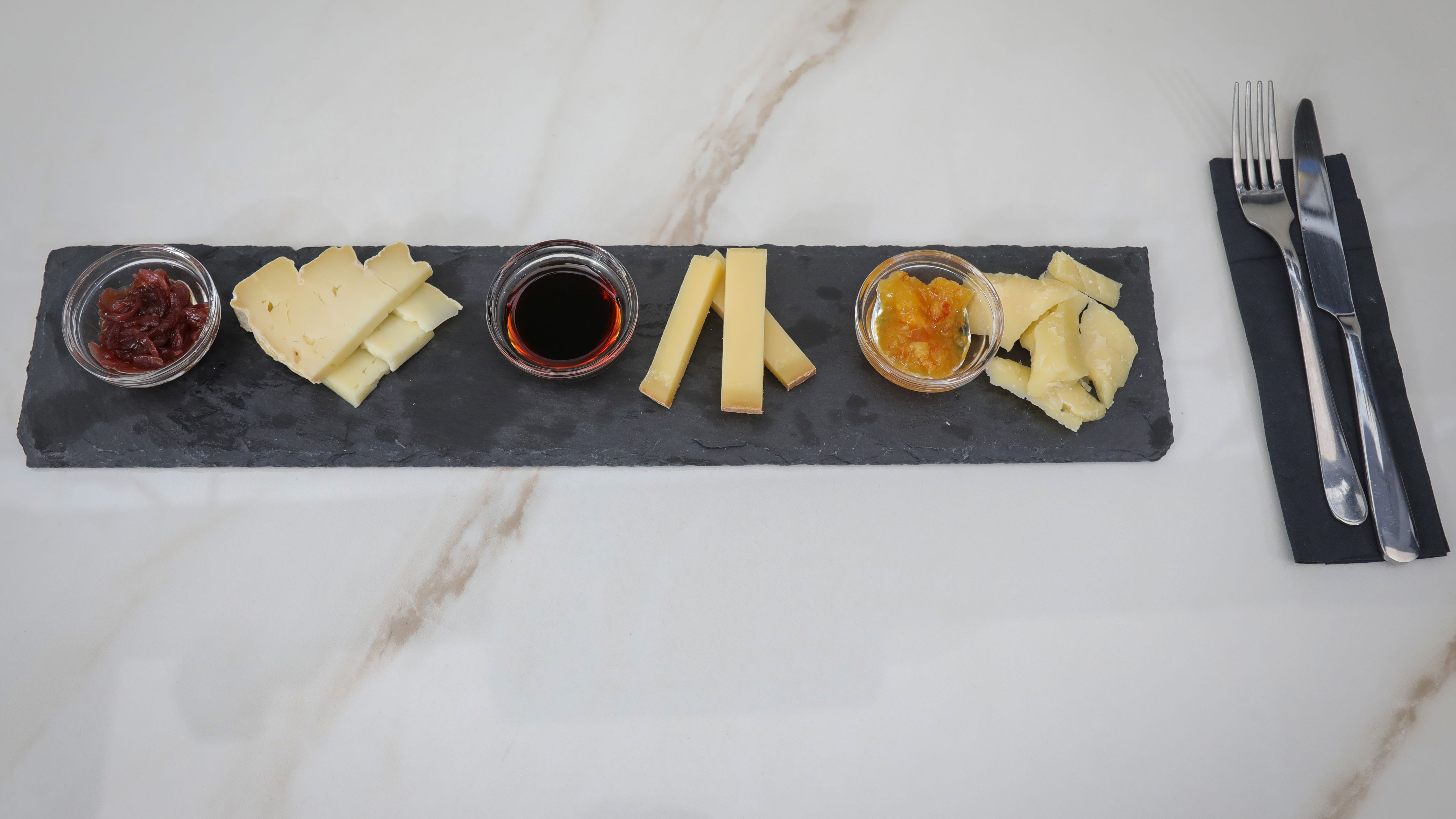 Selezione di formaggi con composte e aceto balsamico