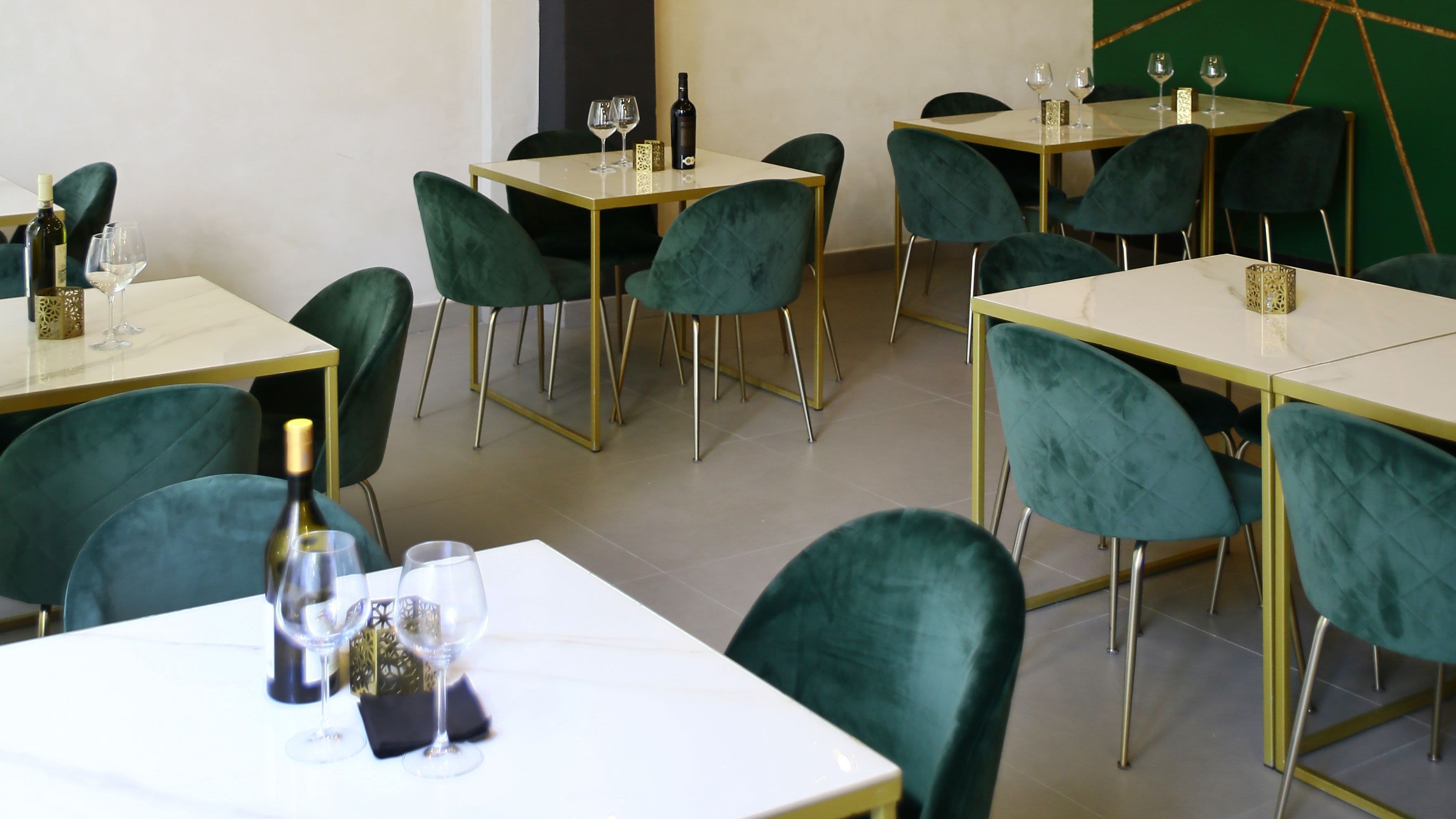 Sala di Symposium con sedute verde smeraldo, tavoli chiari e dettagli dorati